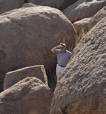 Martin standing next to large boulders